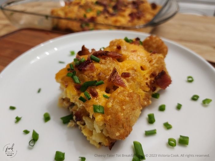 A plated slice of the Cheesy Tater Tot Breakfast Bake garnished with chives.