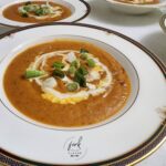 Red Pepper, Carrot & Sweet Potato Soup garnished with sour cream and chopped green onions