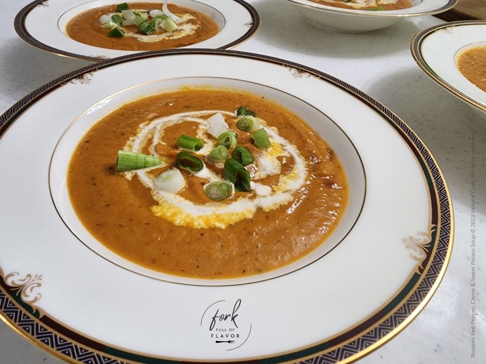 Red Pepper, Carrot & Sweet Potato Soup garnished with sour cream and chopped green onions