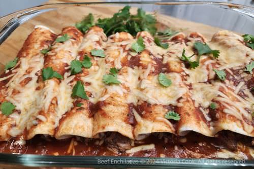A pan of delicious beef enchiladas with red enchilada sauce
