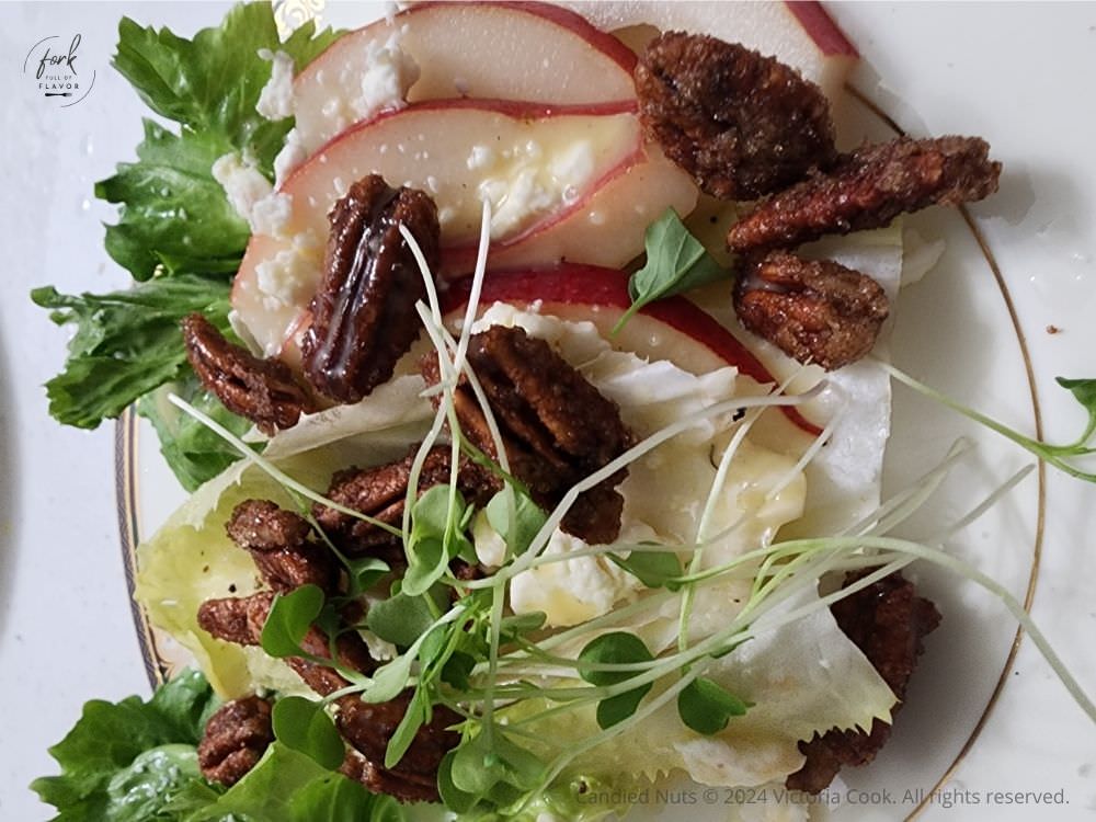 Candied pecans on a mixed green salad with microgreens, cheese and red pears.