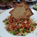 Egg roll bowl made with ground pork plated and served with an air-fried wonton