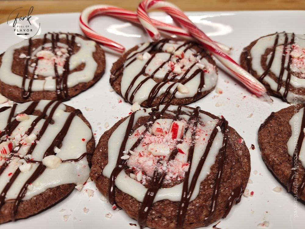 Chocolate Peppermint Cookies - Hero A plate of chocolate peppermint cookies on a plate with candy canes.