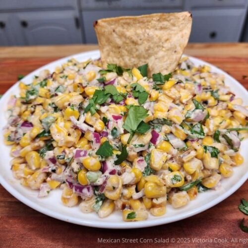 A plate of Mexican street corn salad ready for dipping into with taco chips